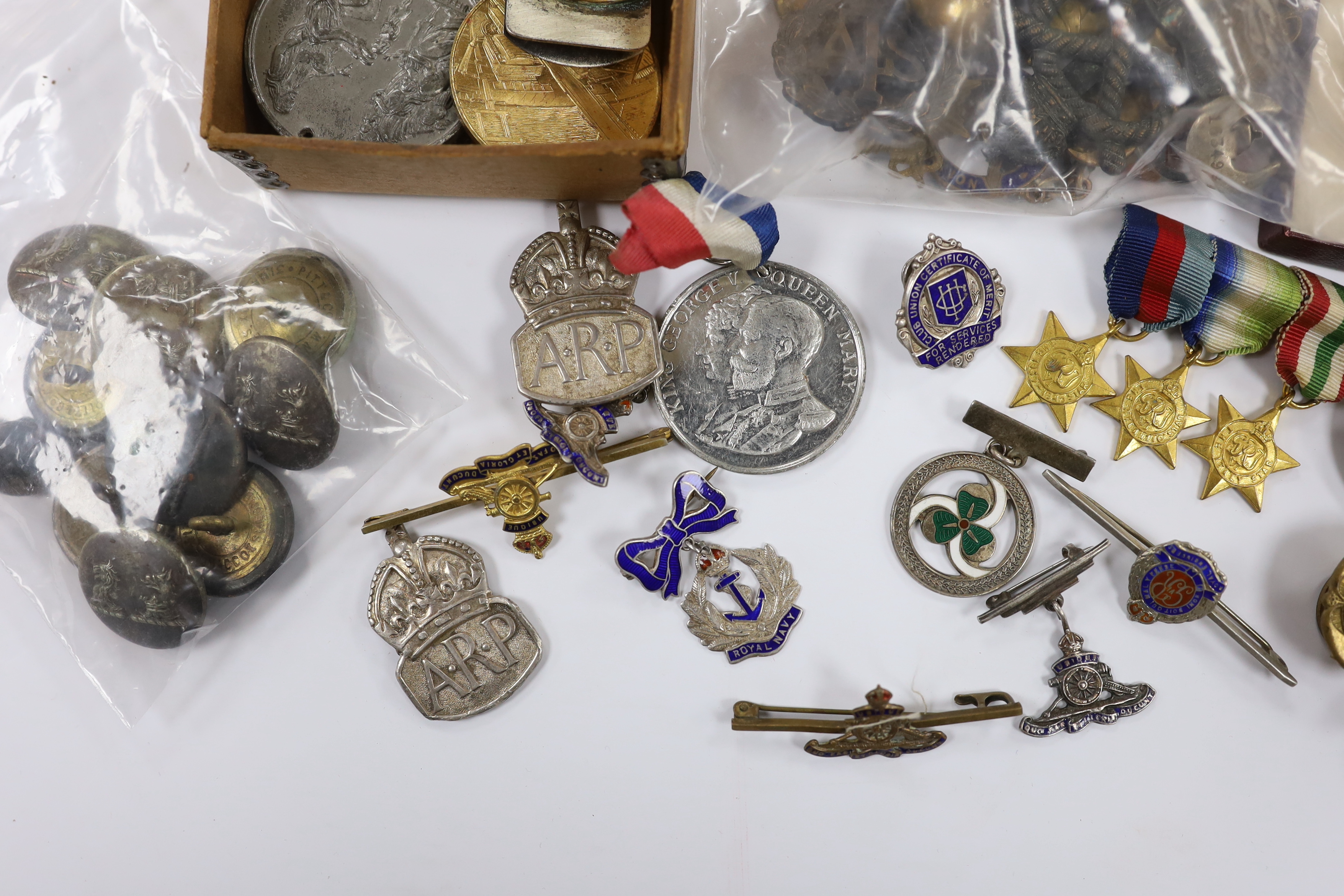 A collection of medals, cap badges, commemorative coins etc. including; a cased RMS Lusitania medal, Royal Artillery sweetheart brooches, a miniature WWII medal group of three stars; the 1939-45 Star, the Atlantic Star a
